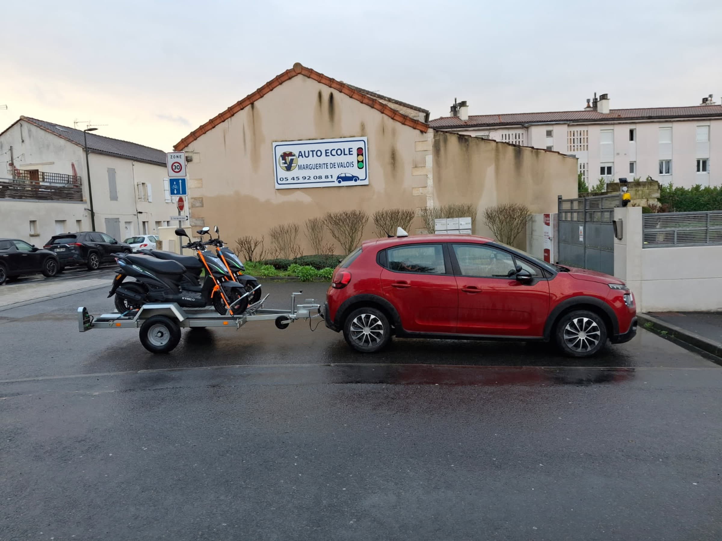 Scooter et voiture ECMV devant l'agence Marguerite de Valois